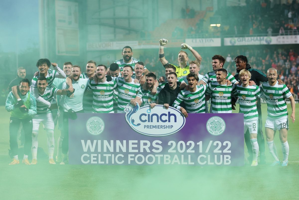 Das Team von Celtic feiert den Meistertitel im Stadion von Dundee United, umgeben von grünem Rauch.