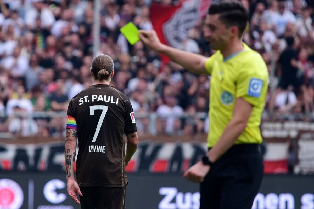 Jackson Irvine (FC St. Pauli) wird mit einer Gelben Karte verwarnt beim Spiel zwischen dem FC St. Pauli und dem 1. FC Magdeburg (Copyright: Peter Boehmer)