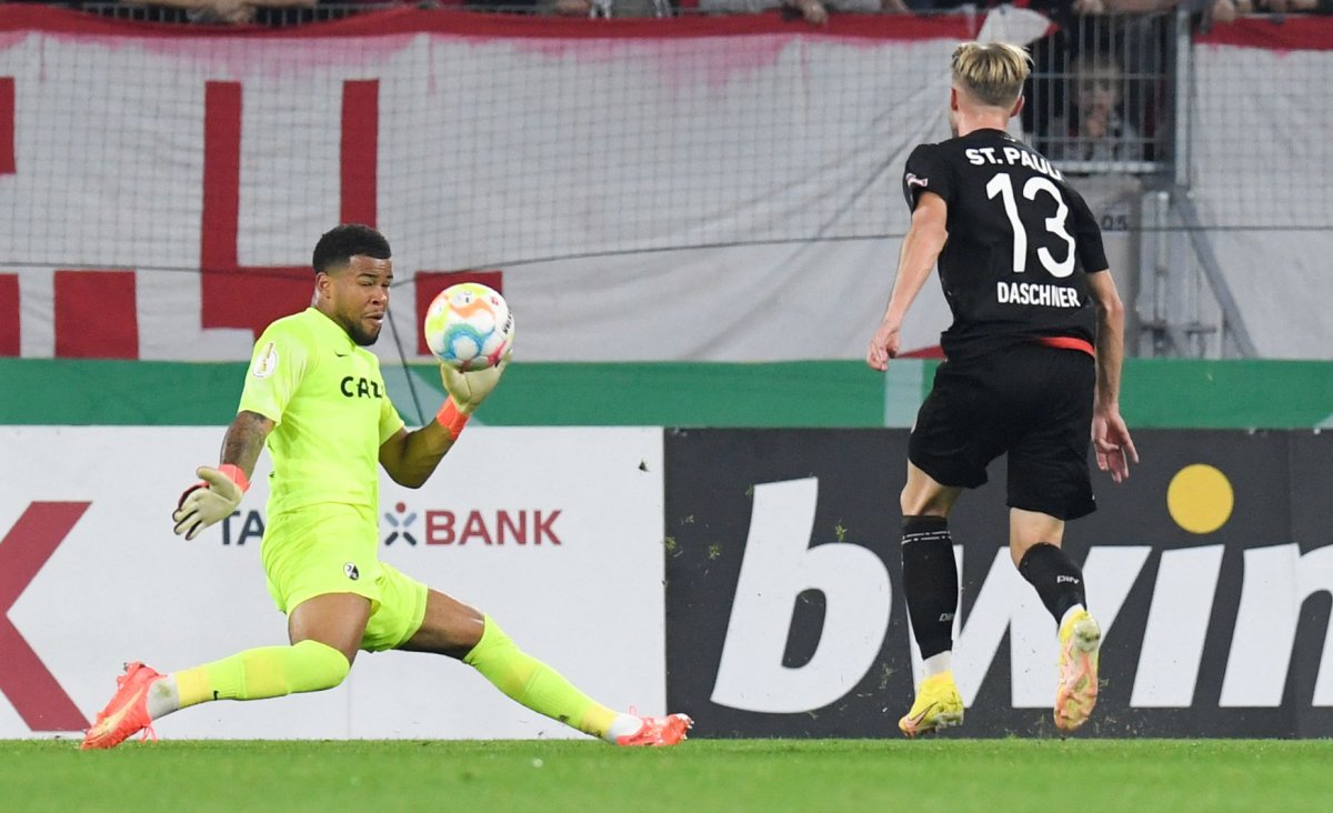 St Pauli's German midflielder Lukas Daschner (R) scores the 0-1 past Freiburg's German goalkeeper Noah Atubolu during the German Cup (DFB Pokal) second round football match between German first division Bundesliga team SC Freiburg and German second division Bundesliga team FC St Pauli in Freiburg, southwestern Germany, on October 19, 2022. - - DFB REGULATIONS PROHIBIT ANY USE OF PHOTOGRAPHS AS IMAGE SEQUENCES AND QUASI-VIDEO. (Photo by THOMAS KIENZLE / AFP)
