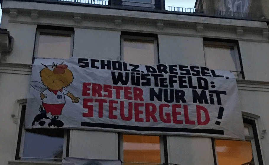 Ein Transparent an einer Hauswand: 
"Scholz, Dressel, Wüstefeld: Erster nur mit Steuergeld".