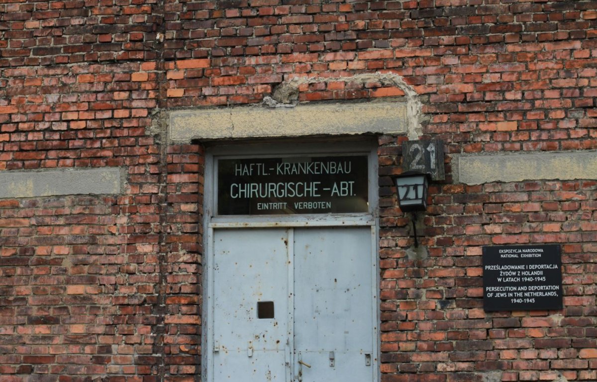 Eingangstür zu Block 21, heute Standort der Länderausstellung der Niederlande.
Rechts der Tür ist ein Schild, welches auf die Länderausstellung in polnischer und englischer Sprache hinweist.
