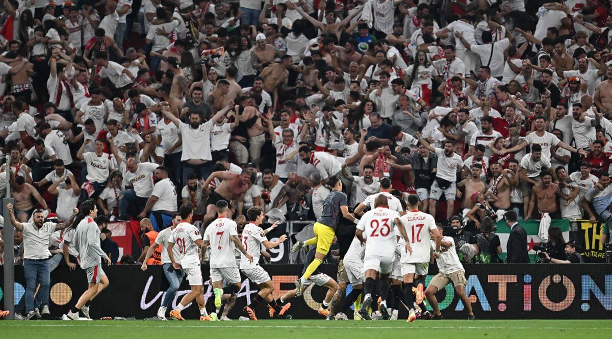 Die Spieler von Sevilla feiern nach dem entscheidenden Elfmeter vor ihrer Kurve, in der alle ausrasten.