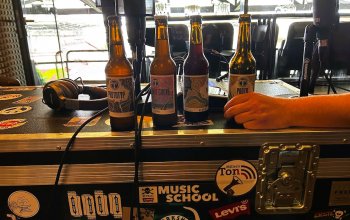 Foto aus der Levi's Music School. Vier Flaschen Bier der Kehrwieder Kreativbrauerei, Podcast-Equipment und im Hintergrund das Millerntor.