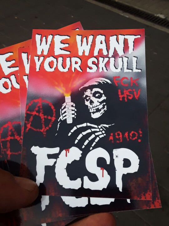 "We want your skull"
Zu sehen ist ein Skelett mit Pyrotechnik, dazu u.a. ein "FCK HSV"-Schriftzug.