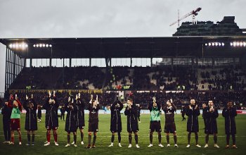Das Team des FC St. Pauli feiert nach dem 1:0 gegen Eintracht Braunschweig (18.02.2024) vor der Südkurve mit den Fans.