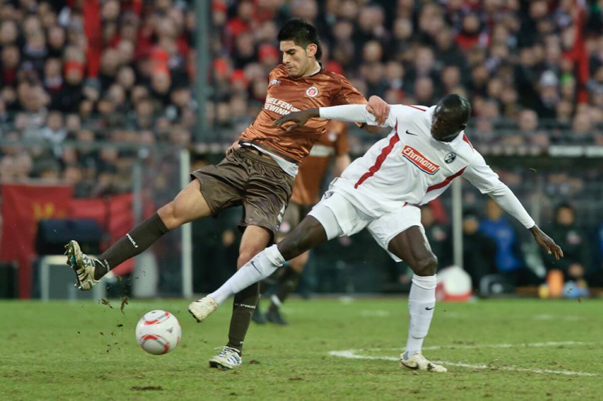 In der letzten Begegnung in der Bundesliga kämpfen je ein Spieler des FC St. Pauli und des SC Freiburg um den Ball.