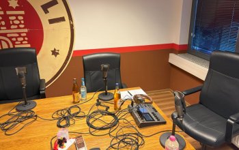 Tisch mit Podcast-Aufnahme-Equipment, im Hintergrund das Vereinslogo des FC St. Pauli