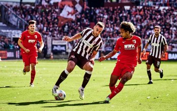 Hamburg, Deutschland, 14.09.2025, Millerntor-Stadion, FC St. Pauli - FC Augsburg James Sands (FC St. Pauli) im Zweikampf mit Han-Noah Massengo (FC Augsburg). Copyright: Stefan Groenveld