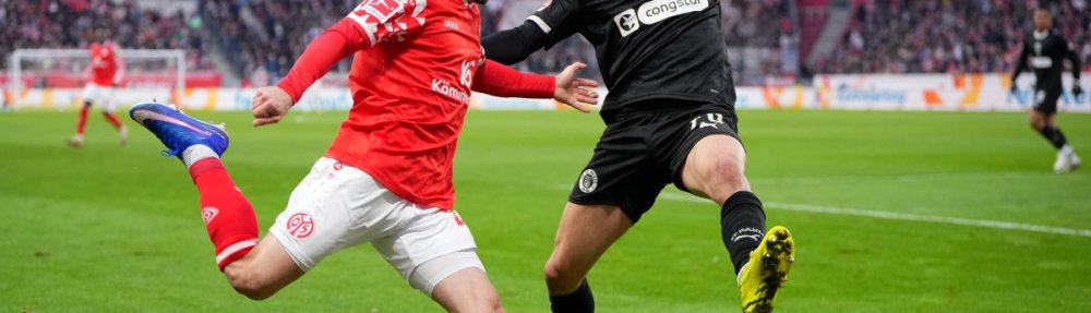 MAINZ, GERMANY - DECEMBER 21: Paul Nebel of 1. FSV Mainz 05 passes the ball whilst under pressure from Mathias Pereira Lage of FC St. Pauli during the Bundesliga match between 1. FSV Mainz 05 and FC St. Pauli at MEWA Arena on December 21, 2025 in Mainz, Germany. (Photo by Pau Barrena/Getty Images)