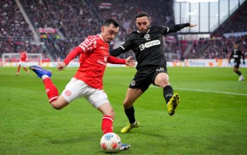 MAINZ, GERMANY - DECEMBER 21: Paul Nebel of 1. FSV Mainz 05 passes the ball whilst under pressure from Mathias Pereira Lage of FC St. Pauli during the Bundesliga match between 1. FSV Mainz 05 and FC St. Pauli at MEWA Arena on December 21, 2025 in Mainz, Germany. (Photo by Pau Barrena/Getty Images)