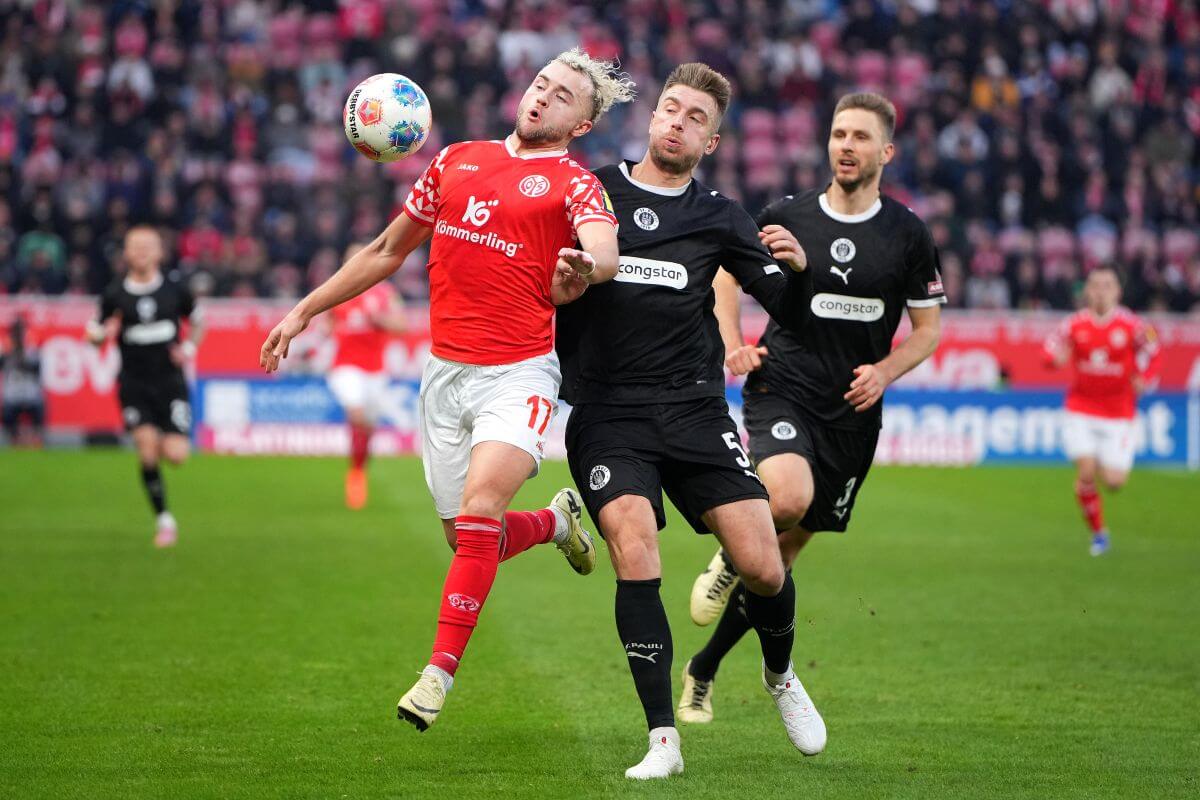 MAINZ, GERMANY - DECEMBER 21: Benedict Hollerbach of 1. FSV Mainz 05 is challenged by Hauke Wahl of FC St. Pauli during the Bundesliga match between 1. FSV Mainz 05 and FC St. Pauli at MEWA Arena on December 21, 2025 in Mainz, Germany. (Photo by Pau Barrena/Getty Images)