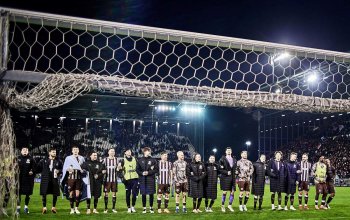 Die Mannschaft des FC St. Pauli verabschiedet sich nach dem Heimsieg gegen den SV Werder Bremen und steht dafür in einer Reihe vor den Fans, im Vordergrund ist ein Tor zu sehen.