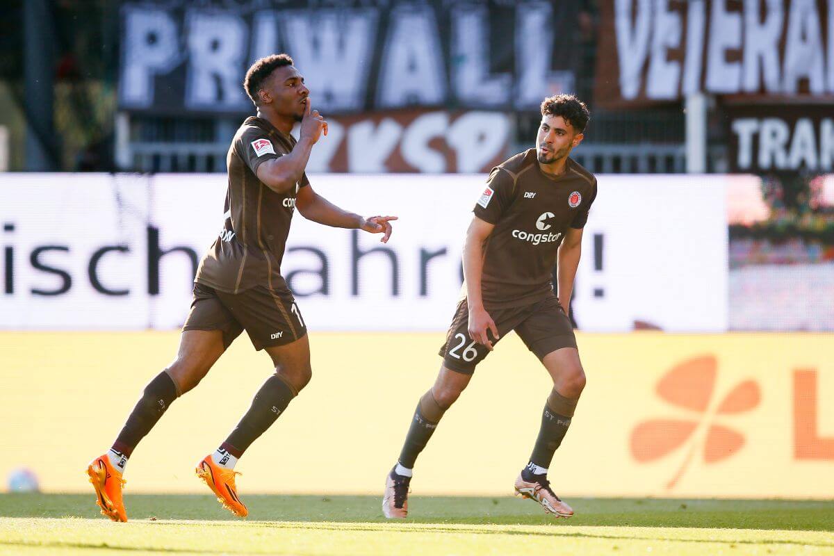 KIEL, GERMANY - MAY 19: Oladapo Afolayan of St. Pauli (L) celebrate their teams first goal scoring with Elias Saad during the Second Bundesliga match between Holstein Kiel and FC St. Pauli at Holstein-Stadion on May 19, 2023 in Kiel, Germany. (Photo by Selim Sudheimer/Getty Images)