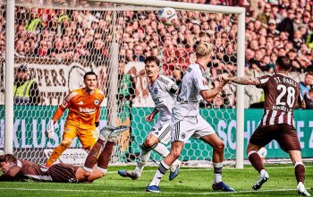 Tomoya Andō (am Boden) hat den Ball soeben mit dem Kopf nach hinten abgelegt, Mathias Pereira Lage (beide FC St. Pauli) wird ihn im Spiel gegen Eintracht Frankfurt gleich an den Pfosten schießen. // 08.03.2026, (c) Stefan Groenveld
