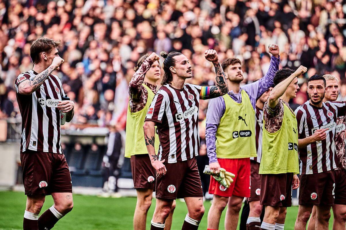 Eric Smith, Jannik Robatsch, Jackson Irvine, Ben Voll, Danel Sinani (halb verdeckt), Martijn Kaars, Mathias Pereira Lage und Louis Oppie (FC St. Pauli) nach dem Spiel gegen Eintracht Frankfurt vor der Kurve. // 08.03.2026 (c) Stefan Groenveld