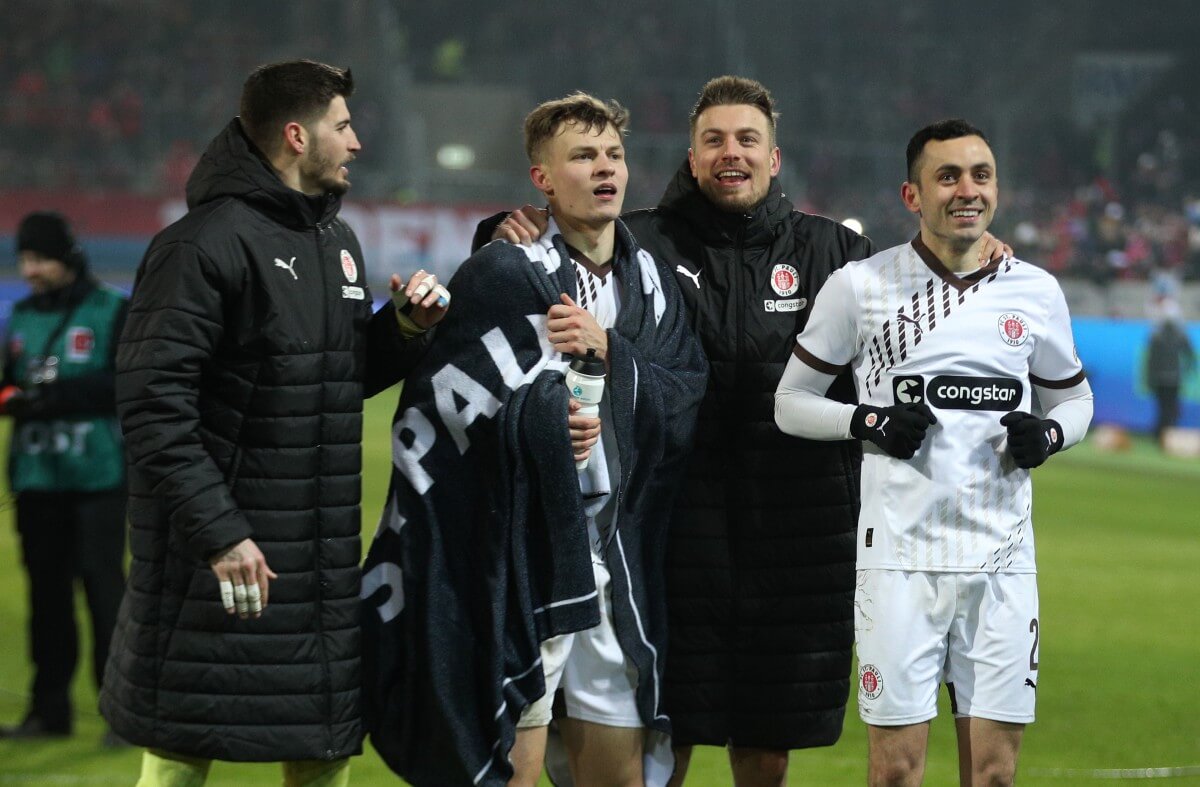 Nikola Vasilj, David Nemeth, Hauke Wahl und Manolis Saliakas (FC St. Pauli) feiern nach dem Sieg beim 1. FC Heidenheim am 18.01.2025 vor der Gästekurve. // (c) Leonhard Simon / Getty Images via OneFootball