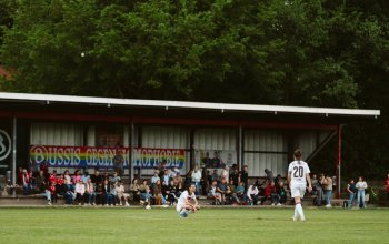 Gianna Nicoleit (FC St. Pauli) in der Hocke nach dem Spiel beim ATS Buntentor. Im Hintergrund ein "Bussies gegen Homophobie"-Banner. // (c) @eddy.photogr