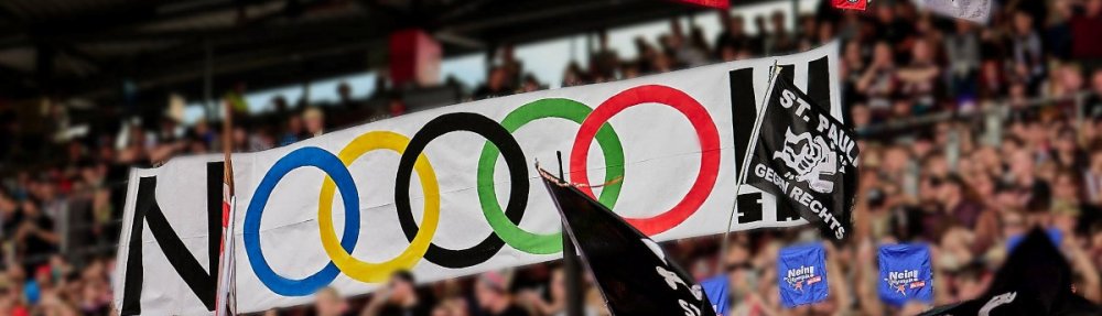 "NOOOOO!!!"-Tapete auf der Gegengerade beim Heimspiel gegen Mainz 05. Die Buchstaben O sind in Form der olympischen Ringe dargestellt.