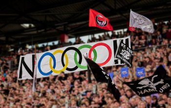"NOOOOO!!!"-Tapete auf der Gegengerade beim Heimspiel gegen Mainz 05. Die Buchstaben O sind in Form der olympischen Ringe dargestellt.