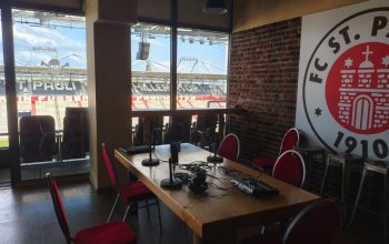 Podcast-Setup in einem Separee am Millerntor, im Hintergrund der Blick auf die Gegengerade.