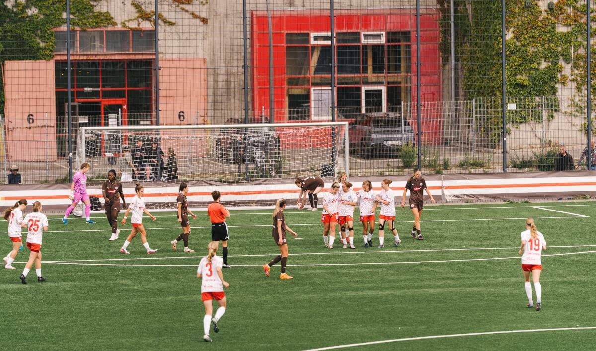 Holstein Kiel (1. Frauen) jubelt über ein Tor beim FC St. Pauli. Das Tor ist weit im Hintergrund zu sehen, vorm Feldstraßen-Bunker, aufgenommen von der Nordkurve aus. // (c) @eddy.photogr