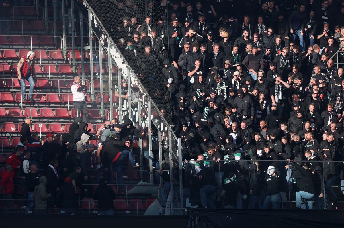 Szene aus dem Kölner Stadion beim Heimspiel gegen Borussia Mönchengladbach am 11.10.2026. Zwischen dem Heimbereich und dem Gästeblock ist die Plexiglas-Abtrennung zerbrochen. Beide Parteien stehen in respektvollem Abstand und betrachten den entstandenen Schaden. // (c) Lars Baron/Getty Images via OneFootball